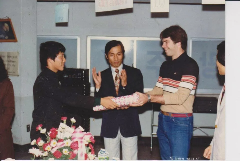 Bill receiving birthday gift from Joseph Cho, YFC student president, November 1982
