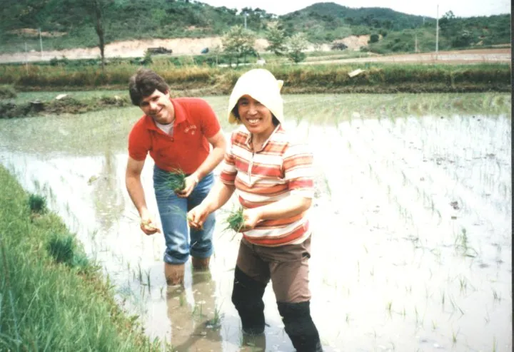 Bill and Korean colleague planting rice barefoot, mid-1980s